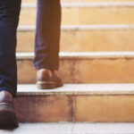 Človek robí malé kroky na ceste symbolizujúcej pozitívne zmeny v každodennom živote.