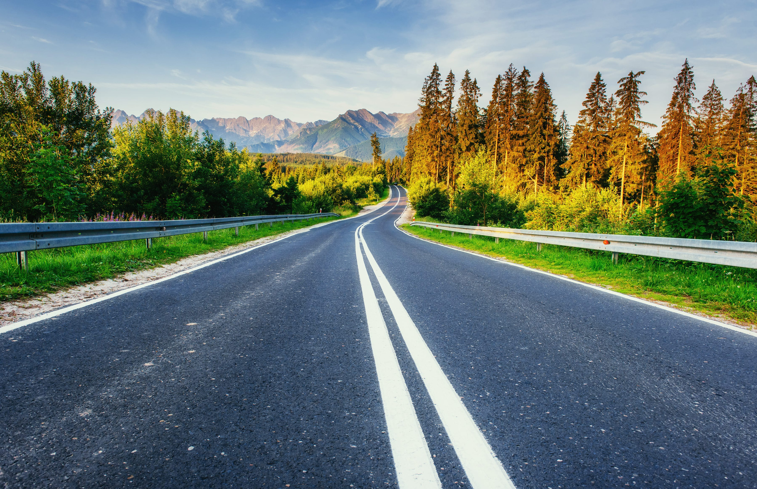 Automobil na vyhliadkovej ceste vedúcej slovenskou prírodou počas víkendového road tripu.